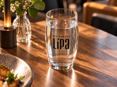 Wasserglas mit Restaurantlogo auf einem gedeckten Tisch